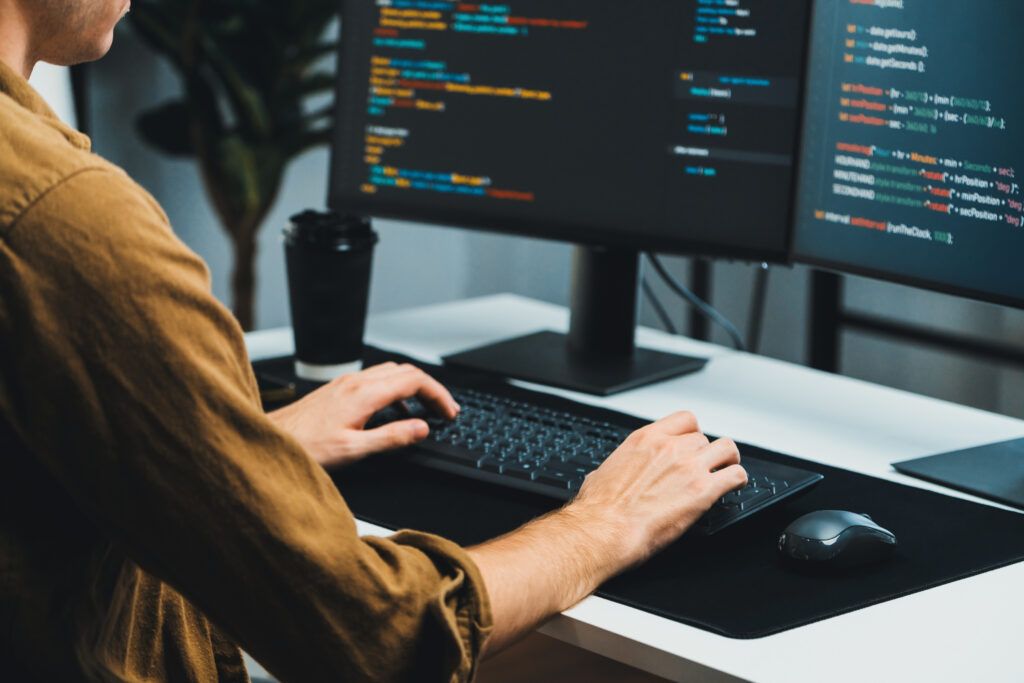 IT developer working online software development coding on pc screens. Gusher.